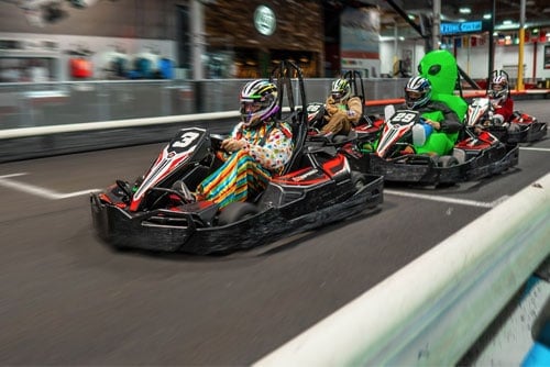 racers dressed in costumes drive go karts