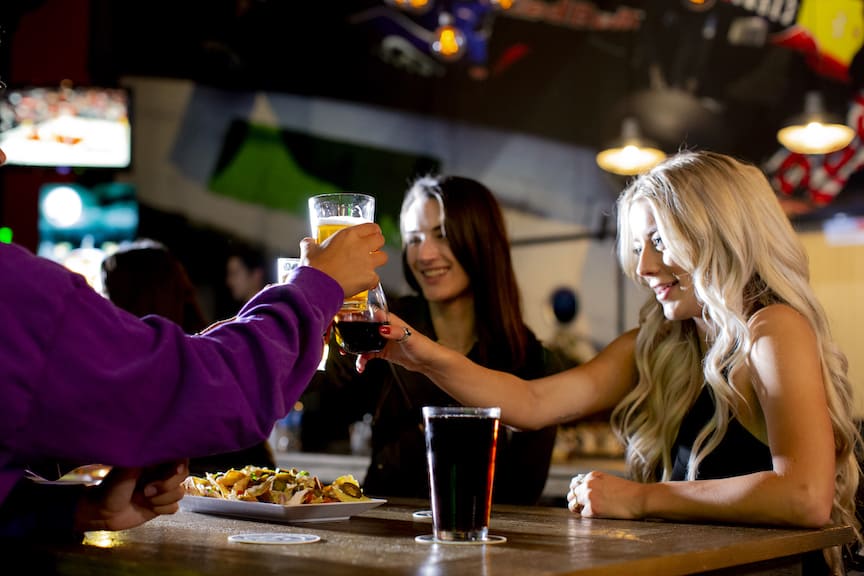 Visitors enjoying beer and nachos at K1 Speed Irvine's Paddock Lounge