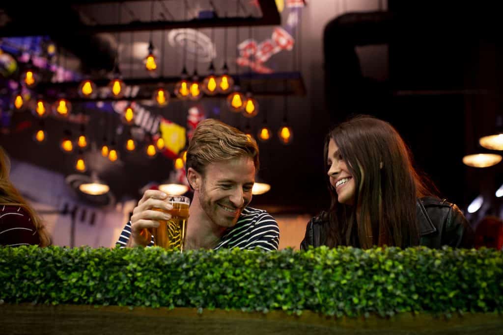 man holds beer at K1 Speed Paddock Lounge