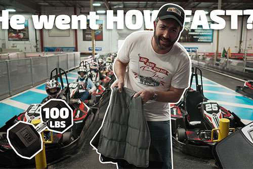 man holds weight vest with scale and go karts in background