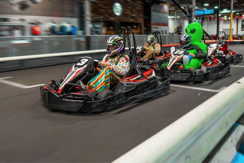 costumed drivers race go karts at k1 speed