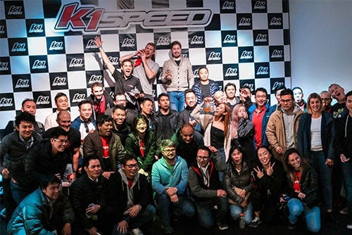 group of coworkers celebrate at k1 speed podium during event