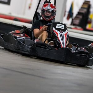 a teenager races a go kart during a birthday party at k1 speed