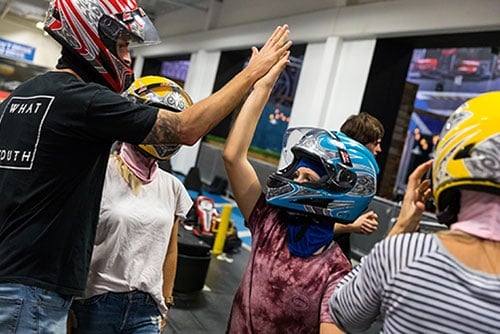 a father and daughter give each other a high five after racing at k1 speed