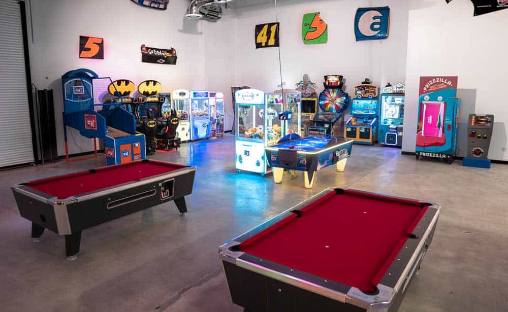 a portion of the arcade inside k1 speed thousand oaks with video games, pool tables, air hockey, and basketball hoops
