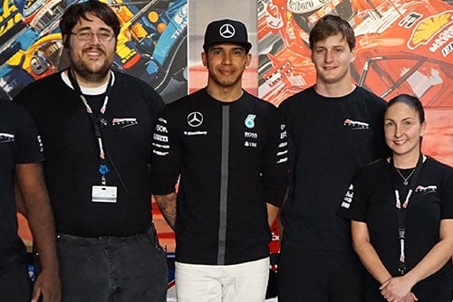 Lewis Hamilton stands with K1 Speed staff at the K1 Speed Austin center