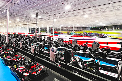 go karts sit in the pits at k1 speed rogers with the track behind them