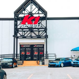 the exterior of k1 speed new orleans with modified cars on display in the parking lot