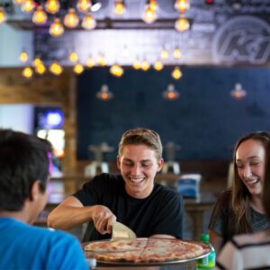 Friends enjoying pizza and soda at K1 Speed
