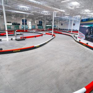 a section of indoor track at k1 speed chula vista with a graphic of lewis hamilton on the wall