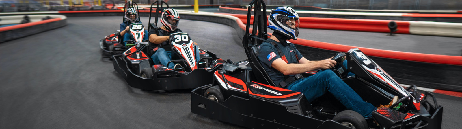 Trois karts en pleine course sur la piste K1 Speed Le Mans