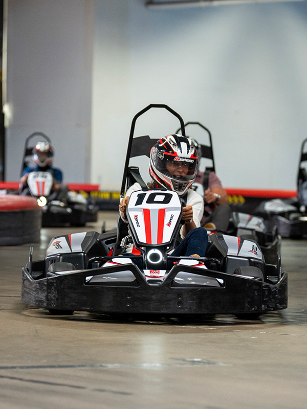 an adult racing a go kart during a birthday party