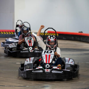 woman cheers while racing go karts at k1 speed during a corporate event
