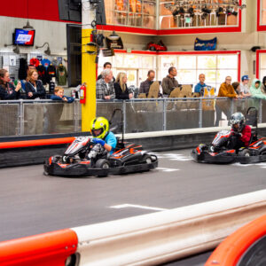 a line of people watch as kids race across the start-finish line at k1 speed's junior us championship