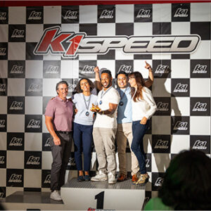a corporate event group stands on the podium at k1 speed after a company team building event