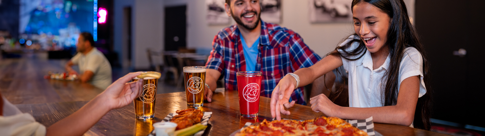 Header image of dad and daughter sharing pizza at the Paddock Lounge