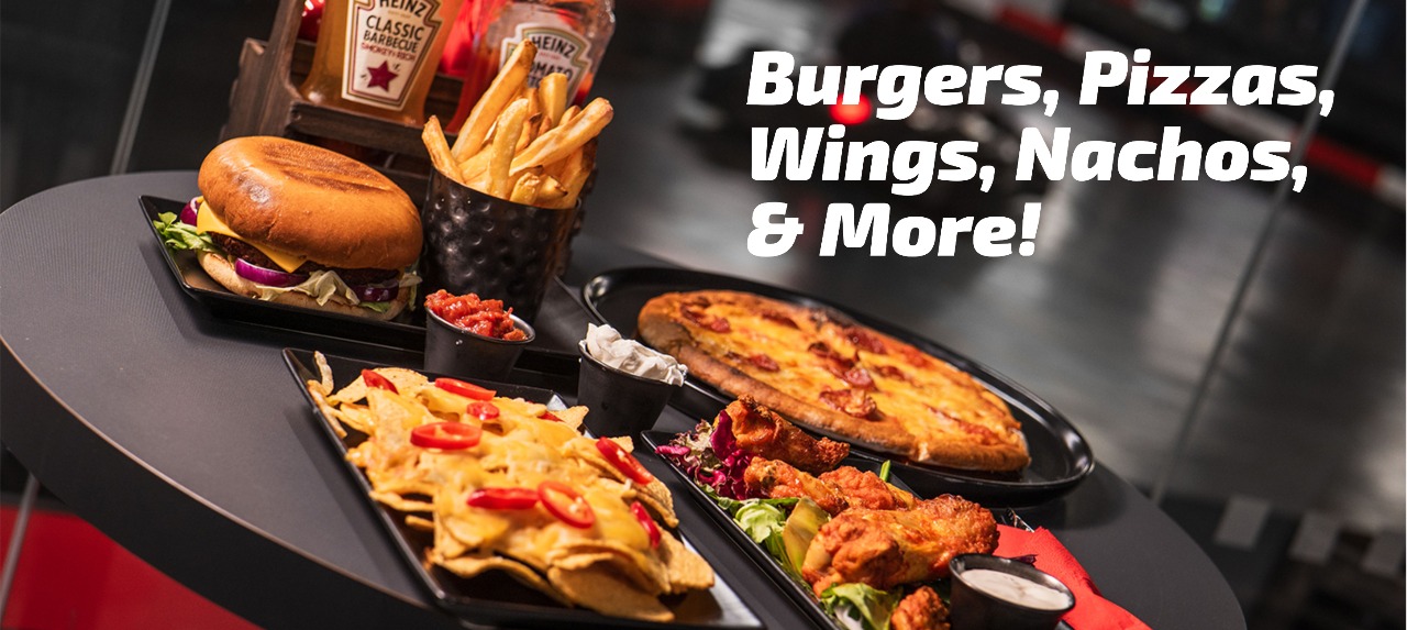 nachos, burger, wings, and pizza on a taable at k1 speed in canary wharf