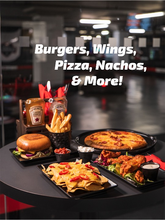 nachos, burger, wings, and pizza on a taable at k1 speed in canary wharf