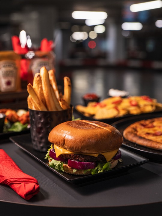 close up shot of cheeseburger, fries, and other food items
