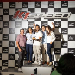 Adults celebrate on the podium at K1 Speed during a retirement party