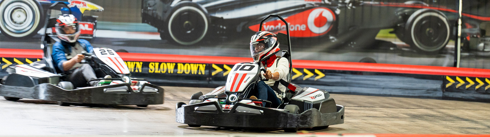 two business professionals race go-karts at k1 speed during a corporate event