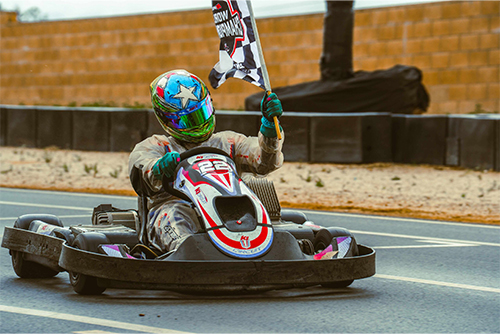 Velez takes a victory lap with the checkered flag in his left hand.