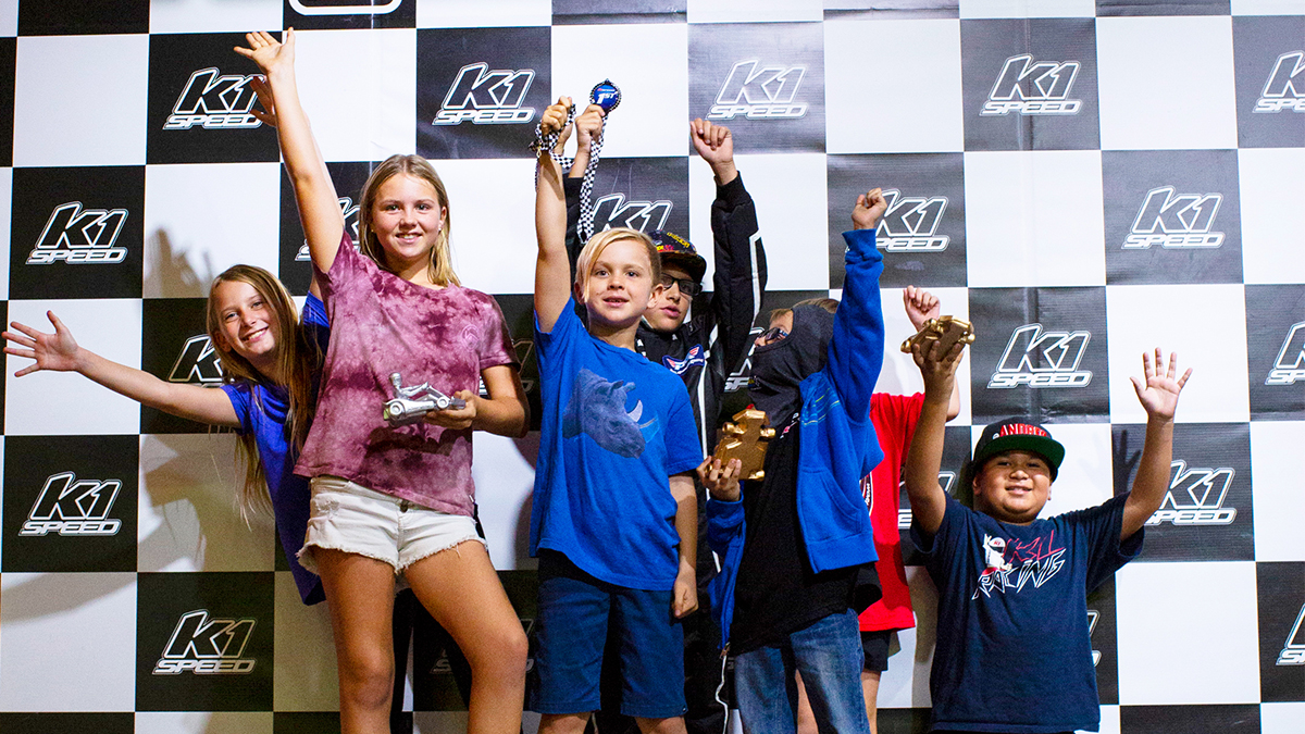 Group of kids celebrating a birthday on the podium at K1 Speed.