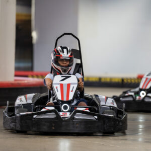 Adults racing go-karts during a party at k1 speed