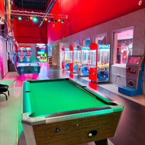 One of the pool tables at K1 Speed Fishers, with arcade games in the background.