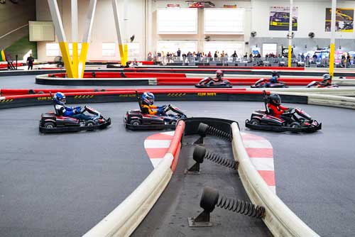 3 karters race for position, trying to overtake at a hairpin.