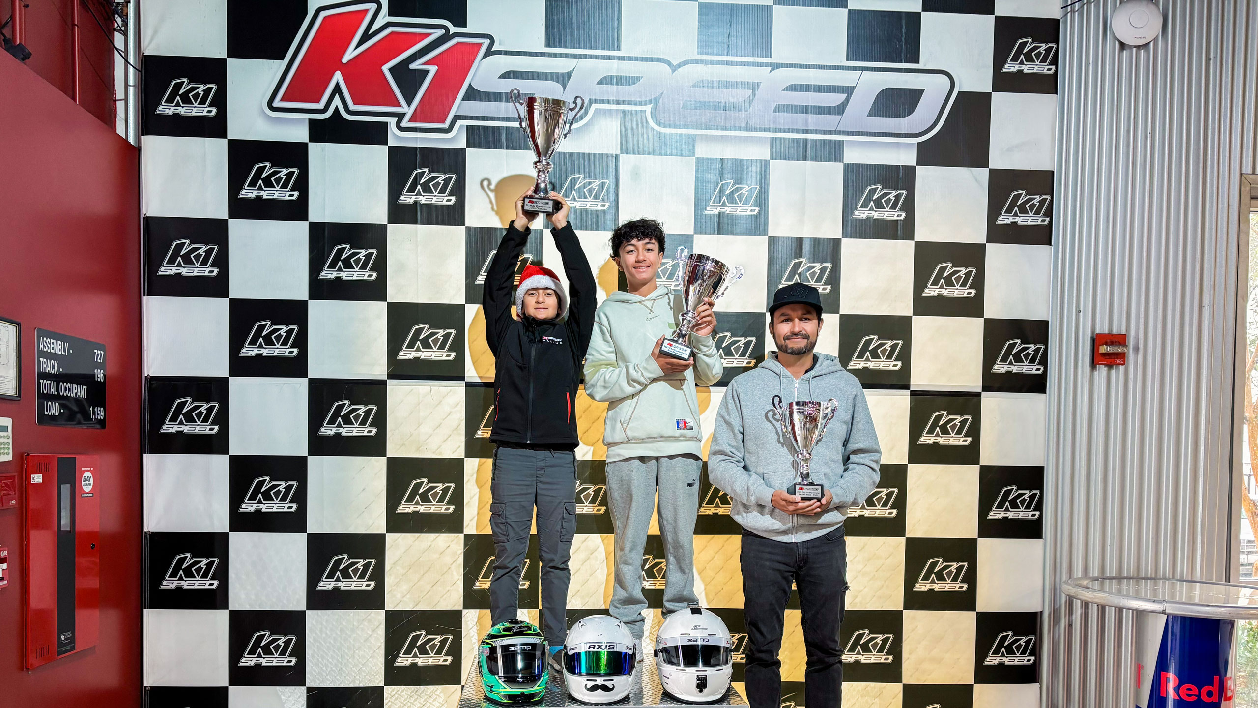 The Ramirez Family stands on the podium together, holding their trophies.