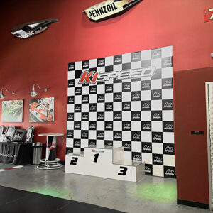 The podium at K1 Speed, with a checkered flag backdrop.