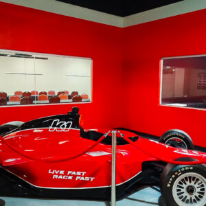 An open-wheel red and black race car on display at K1 Speed West Nyack.