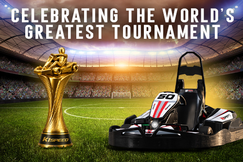 A go-kart sits next to a golden go-kart trophy in a soccer stadium, with text reading "celebrating the world's greatest tournament"